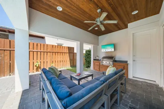 The covered patio is where evenings happen — settle into the sectional, fire up the grill, and let the kids splash in the pool a few steps away.