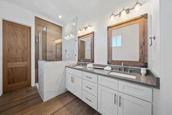 Dual vanity, walk-in tile shower, and a separate toilet room — the master bath is finished with the same care as the rest of the home.