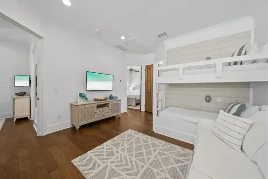 The bunk loft is the kids' kingdom — twin-over-twin bunks, their own TV, and a sofa tucked between both queen bedrooms. No fighting over who sleeps where.