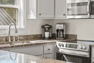 Start your day with a Keurig and a drip coffee maker side by side on the granite counter, next to a stainless steel range.