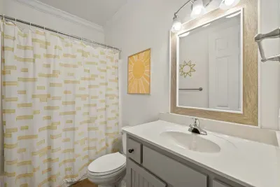 Another full bath has a tub and shower combination, a large vanity and fresh coastal accents.