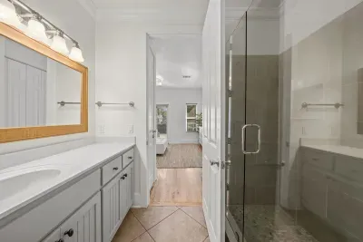 A roomy vanity, framed mirror and glass-enclosed walk-in shower complete the ensuite bath.