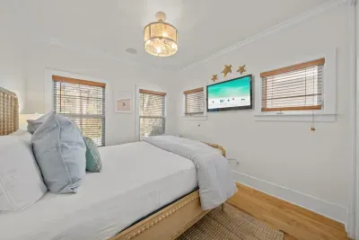 A wall-mounted TV and bright windows make this a relaxing room to wind down at night.
