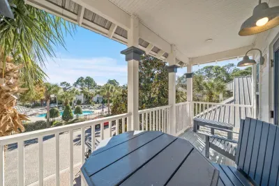 Step out to the walkout balcony with a table, chairs and Adirondack seating, perfect for morning coffee or an evening cocktail looking toward the community pool.