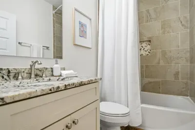 Full bathroom with walk-in shower and granite vanity