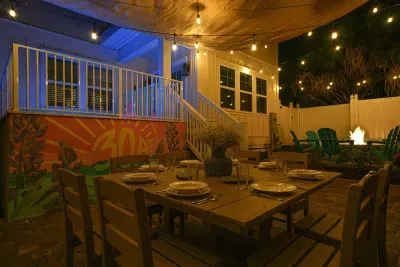 Outdoor dining area with seating for the whole group, café lights overhead, and easy access to the fire pit—perfect for evening meals and relaxed gatherings.