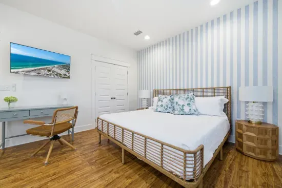Primary bedroom with king bed and calm, coastal-inspired design