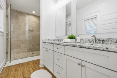 Master bathroom with double vanity and walk-in tiled shower
