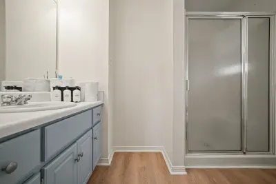 Private ensuite bathroom off the primary bedroom featuring a walk-in shower, spacious vanity, and fresh linens for a comfortable stay.