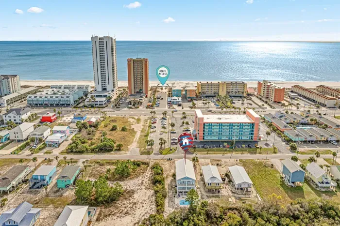 Aerial view showing the home’s location just across the street from the beach, with easy access to the sugar-white sand and Gulf waters only steps away.