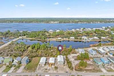 Aerial view showing the home’s peaceful setting along the bay, with water views to both the bay and nearby Gulf beaches.