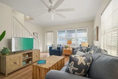 Comfortable living space with plush seating, ceiling fan, and smart TV—an inviting spot to unwind or enjoy a movie night.