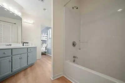 Private ensuite bathroom connected to the bunk room, featuring a full tub/shower combo and ample vanity space.