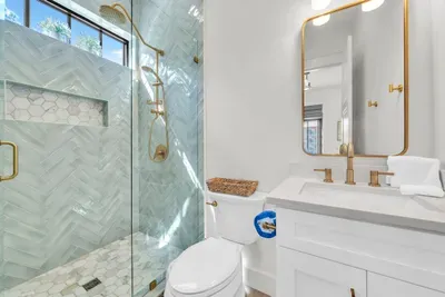 Herringbone tile in the shower and a marble mosaic floor. One of five full baths, so mornings never back up here.