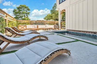 Four loungers line the pool on turf and travertine. Pick one, and let the afternoon take care of itself.