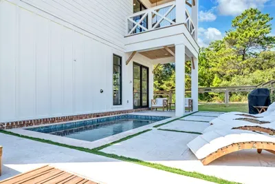 The pool tucks right up against the house, with a covered patio and dining table steps from the water. Swim, eat, repeat.