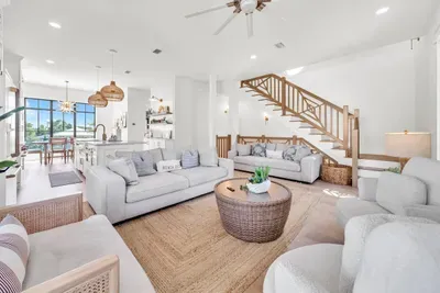 Two sofas, swivel chairs, and a woven coffee table on a jute rug. There is a seat here for all eleven of you when the movie goes on.