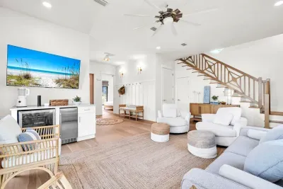 Drop your bags at the door and you are already home. This lounge holds the beverage bar, deep seating, and the stairs up to the main level.