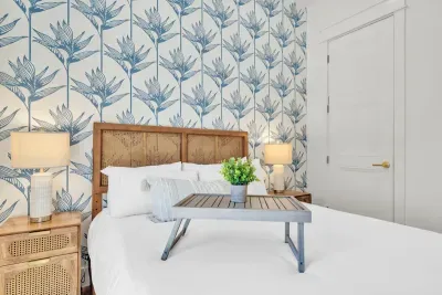 A cane headboard, brass lamps, and a breakfast tray waiting on the bed. The small touches are what make a guest room feel considered.