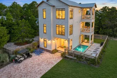 Pull up to this at golden hour and the vacation starts immediately. Three levels of coastal living wrap around a private pool, with a golf cart out front for beach runs and room for everyone to find their own corner.
