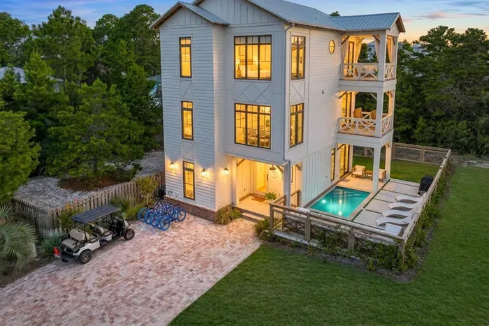 Pull up to this at golden hour and the vacation starts immediately. Three levels of coastal living wrap around a private pool, with a golf cart out front for beach runs and room for everyone to find their own corner.