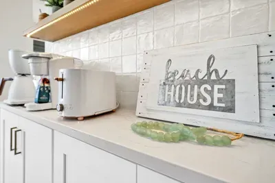 Beach house rules: coffee first. The brewer, the pods, and the toaster all live together on a counter of their own.