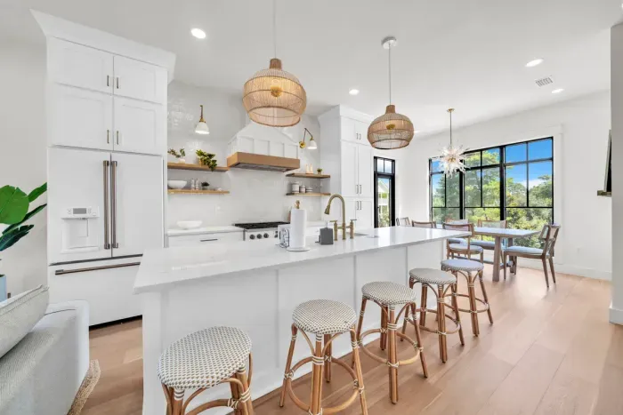 The heart of the house. Five stools pull up to the quartz island, the gas range is a few steps away, and the dining table sits right behind you, so whoever is cooking is never left out of the conversation.