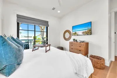 Push open the doors to a small balcony framed by palms. Bed, TV, and a breakfast tray, everything you need to slow the morning down.