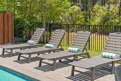 Four lounge chairs poolside and ready — sunscreen optional, relaxation mandatory.