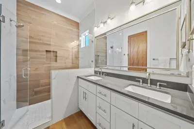 King Ensuite Bathroom
A private ensuite featuring a walk-in tile shower, dual sink vanity, and a separate toilet room.