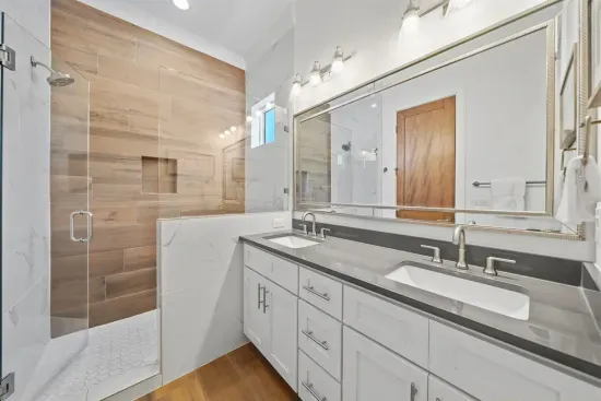 King Ensuite Bathroom
A private ensuite featuring a walk-in tile shower, dual sink vanity, and a separate toilet room.