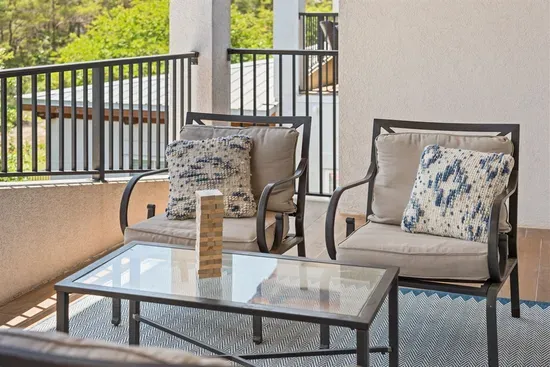 Shaded outdoor seating with peaceful wooded views — the perfect spot to unwind between beach days.