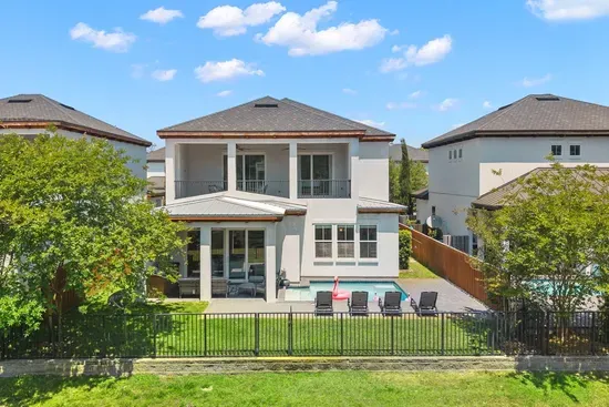 Your private oasis from above — heated pool, lounge chairs, outdoor kitchen, and a fully fenced yard made for making memories.