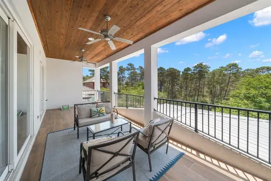A covered outdoor retreat with a ceiling fan and lush surroundings — your quiet escape at the end of the day.