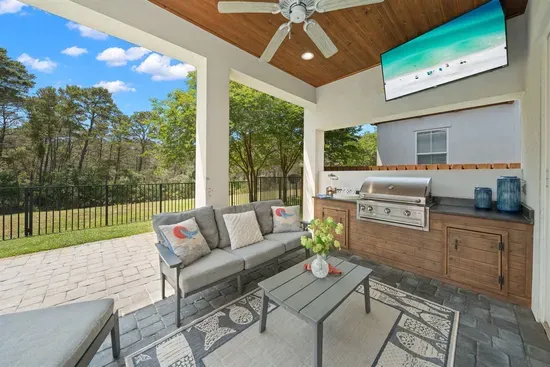 Your outdoor living room — shaded seating, outdoor TV, and the pool just steps away.