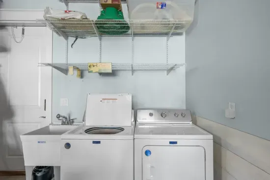 Full size washer and dryer in the guest accessible garage, with a utility sink for rinsing sandy beach gear.