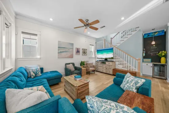 Sink into the sectional after a long beach day. Ten foot ceilings, a ceiling fan, and light from every direction make this the natural gathering spot.
