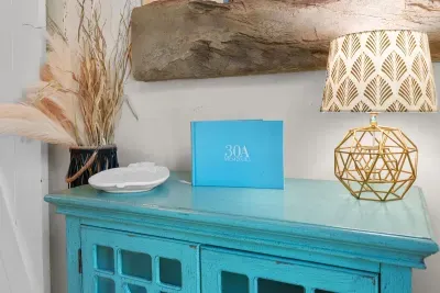 The teal cabinetry and layered textures carry the coastal palette through the whole house.