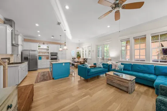 Open sightlines from the sofa all the way through to the kitchen, with ceiling fans and tall ceilings keeping the level airy.