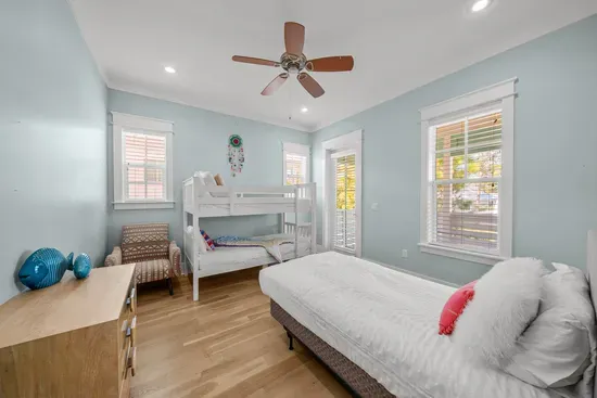 The bunk room sleeps three: a twin over twin bunk plus a separate twin. It opens straight onto the big covered balcony.