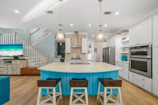 Pull up a stool at the island for a slow morning coffee, with the double wall oven behind you and the stairs to the second floor just past.