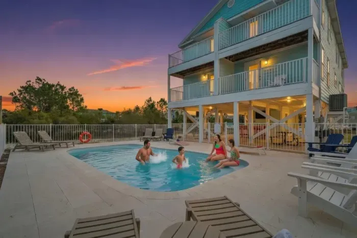 Evenings come alive at the heated saltwater pool—perfect for family time and sunset swims. Enjoy a spacious fenced pool deck with lounge seating, soft evening lighting, nearby grills, and covered picnic table seating for relaxed nights outdoors.