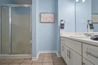 Private ensuite bathroom on the Unit B side featuring a walk-in shower, spacious vanity, and ample storage. Bright, clean, and conveniently connected to the primary bedroom for added comfort and privacy.