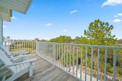 Private walk-out balcony off the Unit A main bedroom, featuring seating and peaceful bay views. A relaxing spot for morning coffee, fresh air, and unwinding after beach days.