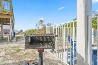 Two Charcoal park-style grills located right by the pool, with covered outdoor picnic table seating nearby—perfect for poolside meals and casual cookouts.