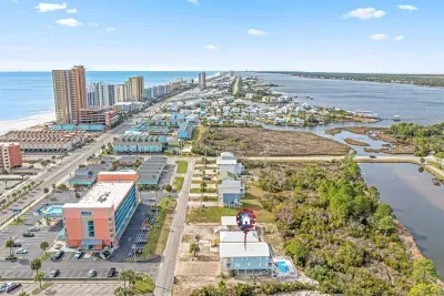 Aerial view showcasing the property’s unique location between the Gulf and the lagoon. Enjoy quick beach access in one direction and peaceful water views in the other, all close to dining, attractions, and the best of Gulf Shores.