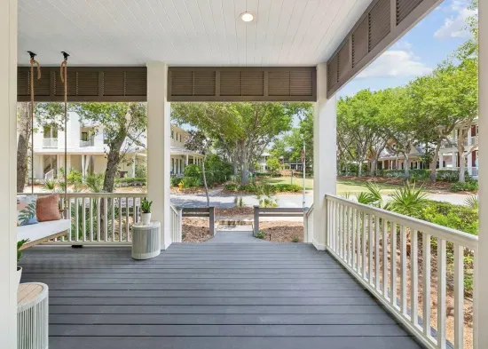 The porch looks straight out onto a grassy pocket park — let the kids run while you keep an eye from the swing.
