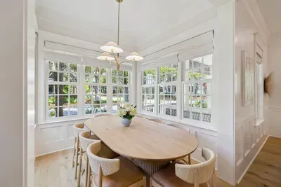 Sunlit family dinners in a wrap-around window nook — a designer West Elm table and chairs with a lush view on every side.
