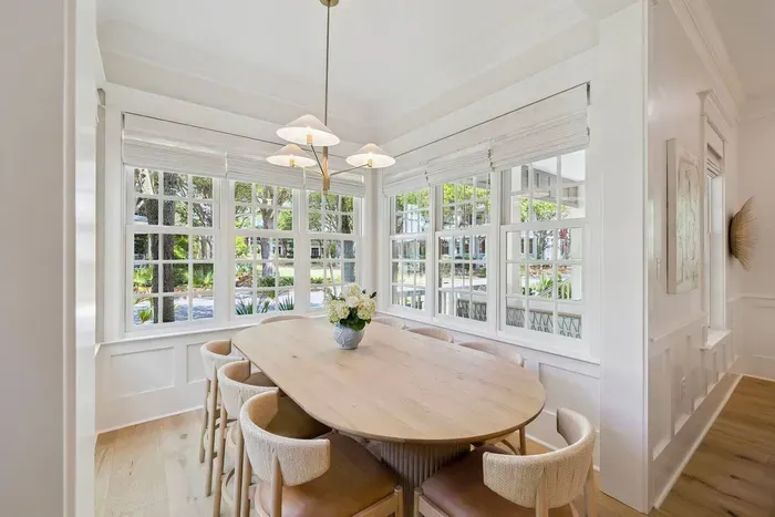 Sunlit family dinners in a wrap-around window nook — a designer West Elm table and chairs with a lush view on every side.