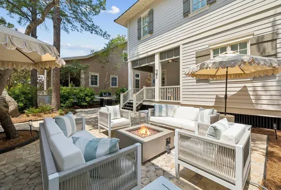 Plenty of room to spread out — the paver patio links the fire pit lounge, the grill, and the back dining porch into one easy outdoor flow.
